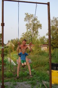 На моём участке качеля - обычная досточка на двух верёвках, переброшенных через перекладину на двух столбах.