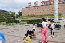 Жители города Фуюань гуляют по площади с собаками мелкой породы.
